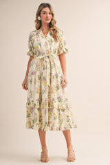 woman wearing a floral midi dress with ruffled sleeves and a tied waist in a light yellow color