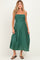 woman wearing a green maternity dress with smocked bodice and spaghetti straps, standing in a relaxed pose
