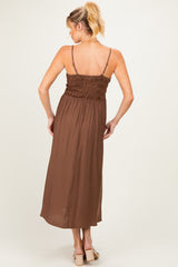 woman wearing a brown maternity maxi dress with a smocked back and spaghetti straps