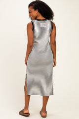 woman wearing a black and white striped sleeveless midi dress with side slits and a round neckline, facing away from the camera