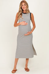 woman wearing a black and white striped maternity dress with side slits and holding her baby bump
