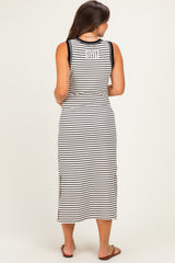 woman wearing a black and white striped maternity maxi dress with side slits and sleeveless design, showing a baby bump