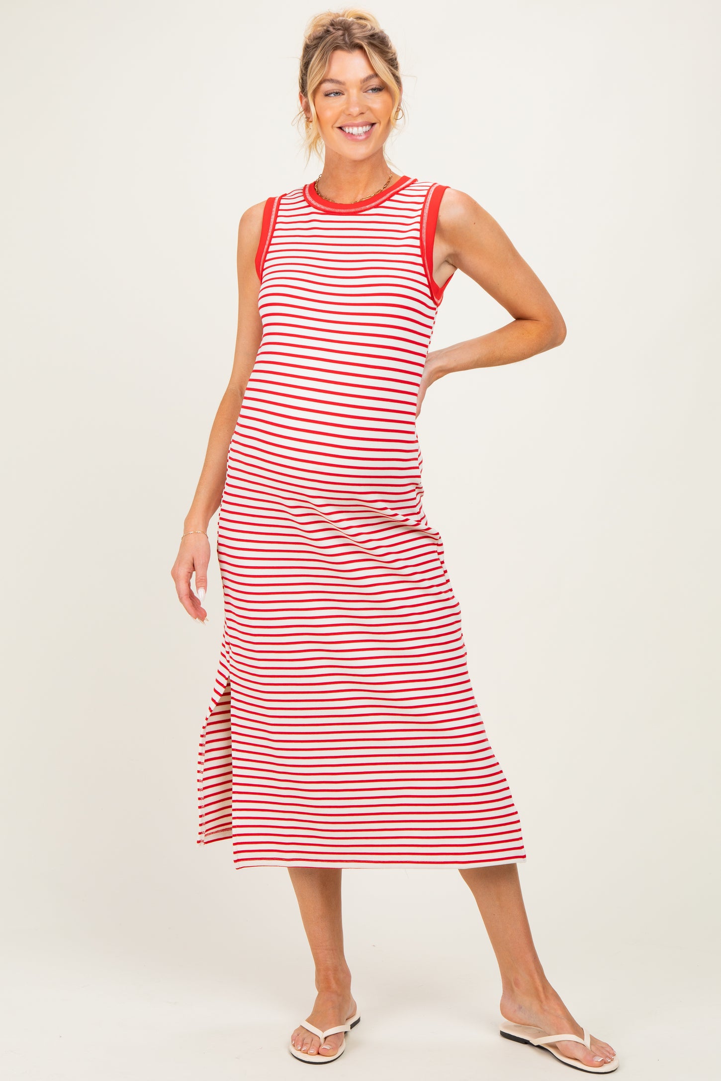 woman wearing a red and white striped maternity dress with a side slit, showing her baby bump