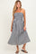 woman wearing a black and white gingham strapless maternity dress with a smocked bodice and flowing skirt, baby bump visible