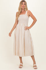 woman wearing a cream and beige striped midi dress with smocked bodice and square neckline