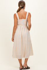 woman wearing a brown and white striped maternity dress with a smocked bodice and shoulder straps, viewed from the back