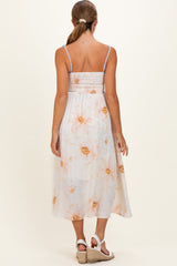 woman wearing a floral print maternity maxi dress with adjustable straps, showing a smocked back and flowing skirt