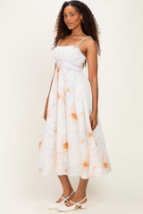 woman wearing a light blue floral midi dress with spaghetti straps and a fitted bodice