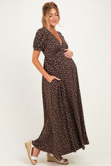 woman wearing a brown maternity maxi dress with white polka dots and pockets, showing her baby bump