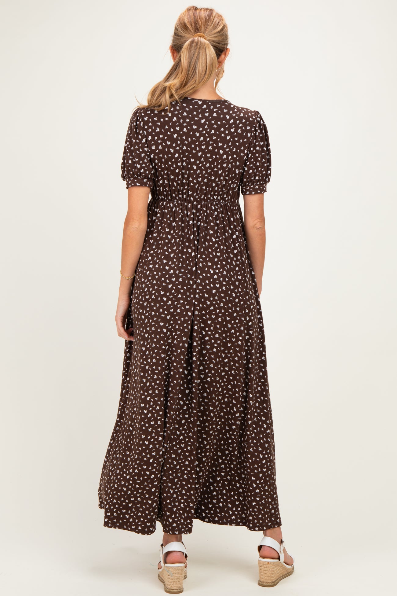 woman wearing a brown floral maternity maxi dress with short puff sleeves and an elastic waistband
