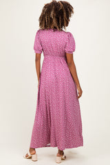 woman wearing a pink polka dot maternity maxi dress with puff sleeves and a fitted waist, seen from the back