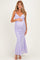 woman wearing a lilac floral print maternity gown and holding her baby bump