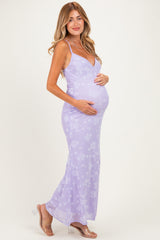 woman wearing a lavender floral maternity dress with a fitted silhouette, cradling her baby bump