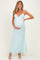 woman wearing a light mint green floral maternity dress with spaghetti straps and a visible baby bump