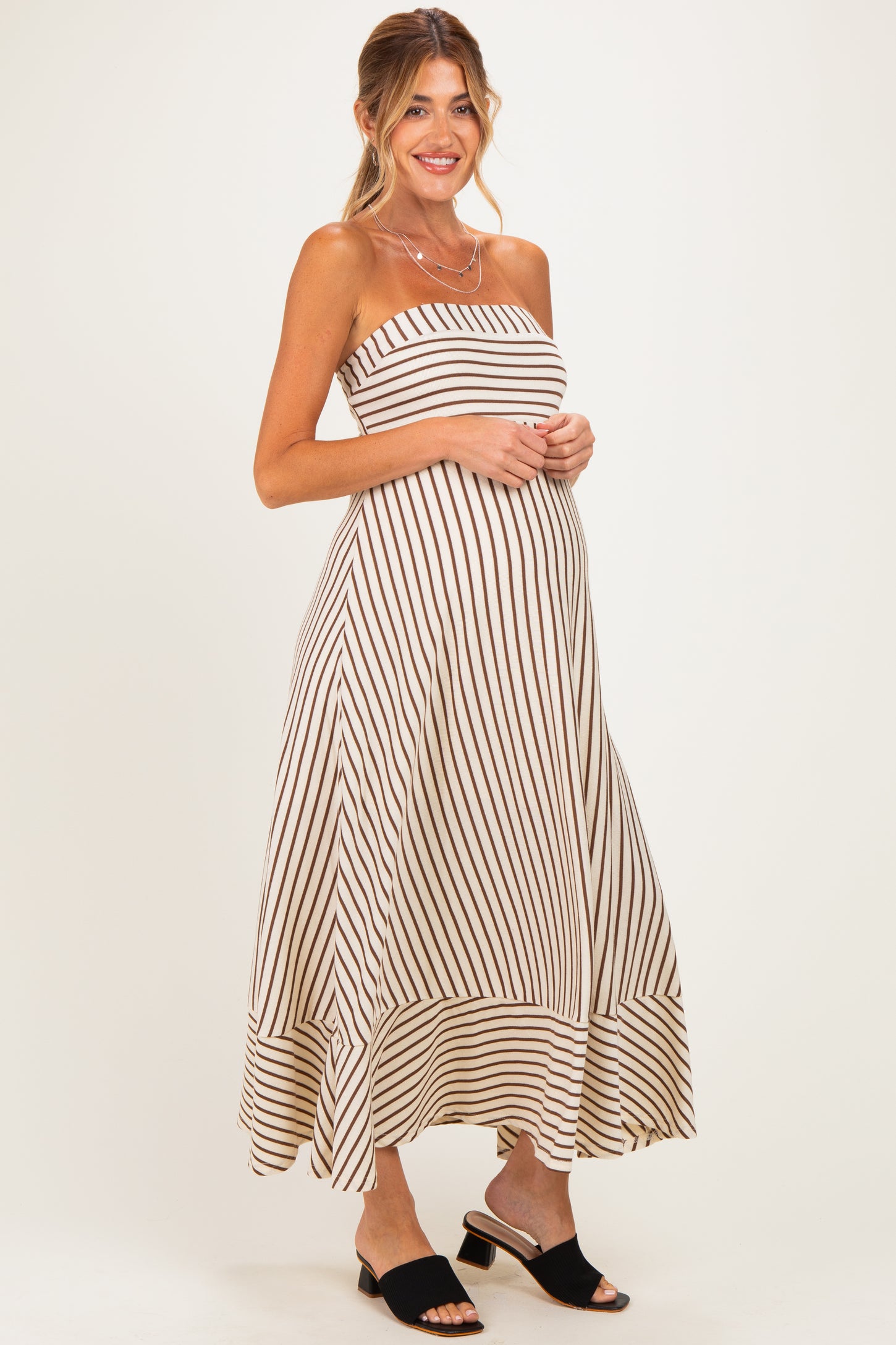 woman wearing a striped maternity maxi dress with a fitted bodice and flowing skirt, showing her baby bump