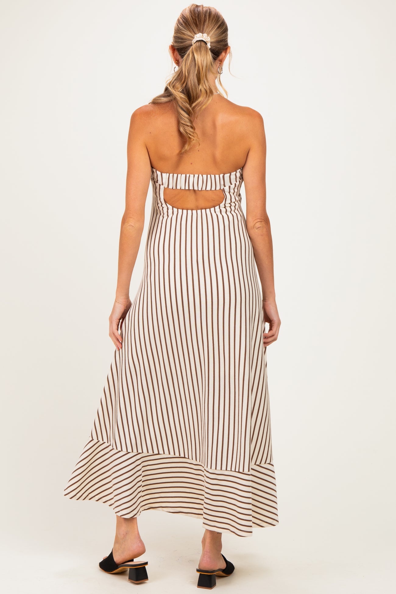 woman wearing a striped backless maternity maxi dress with a flowy hem and a comfortable fit
