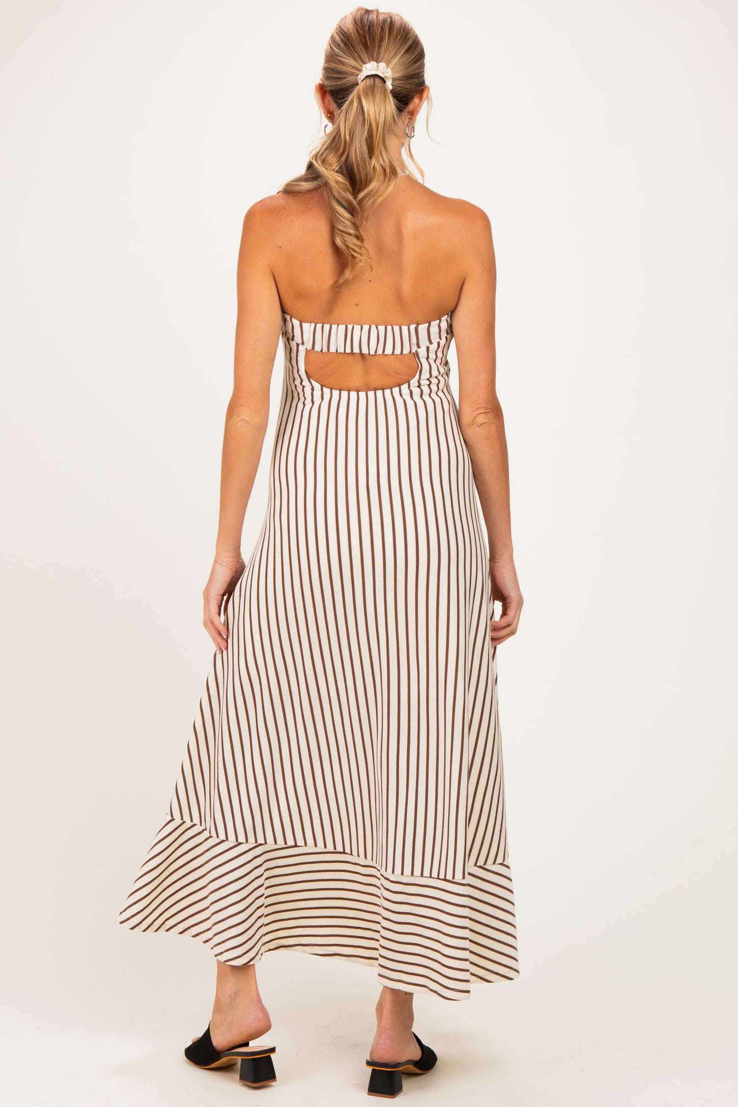 woman wearing a striped backless maternity maxi dress with a flowy hem and a comfortable fit