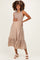 woman wearing a taupe maternity dress with smocked bodice and tiered hem, showcasing her baby bump