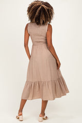 woman wearing a light brown maternity dress with a smocked bodice and tiered ruffle hem, showing her back