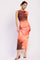 woman wearing a two-piece orange tie-dye crop top and matching midi skirt with a slim fit