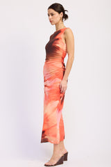 woman wearing an orange and brown tie-dye maxi dress with ruching detail and a sleek silhouette