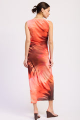 woman wearing a sleeveless maxi dress with a colorful abstract print in shades of pink and brown, seen from the back
