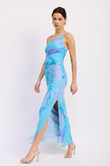 woman wearing a blue and purple floral print maxi dress with ruching and high slits, paired with silver heels