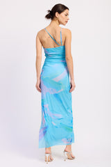 woman wearing a blue maxi dress with abstract pastel print and spaghetti straps, viewed from the back