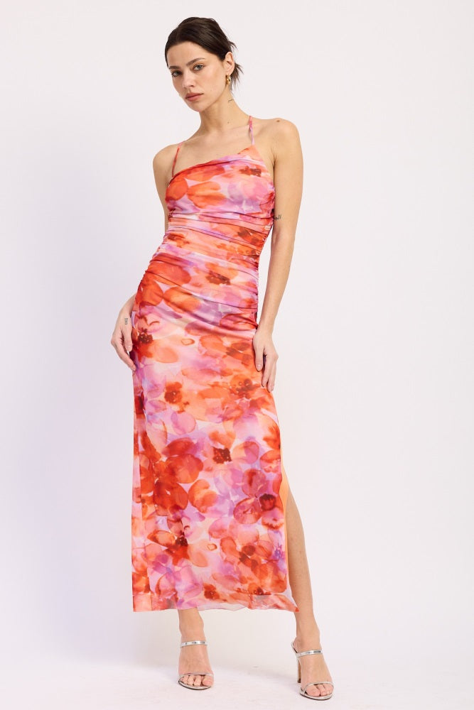 woman wearing a pink and orange floral maxi dress with a side slit and halter neckline