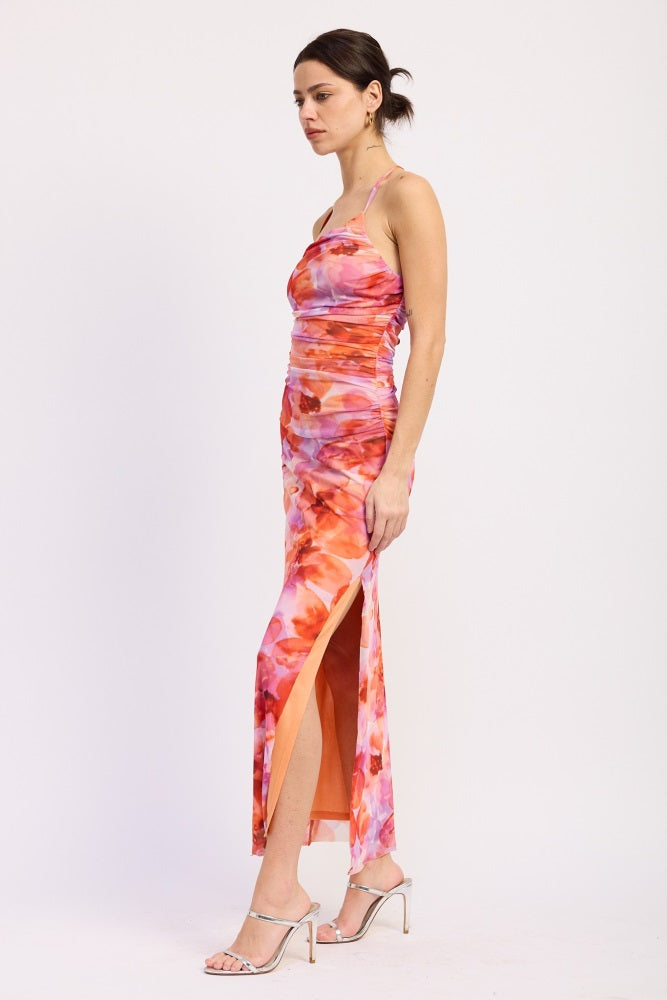 woman wearing a floral print satin maxi dress with a side slit and spaghetti straps