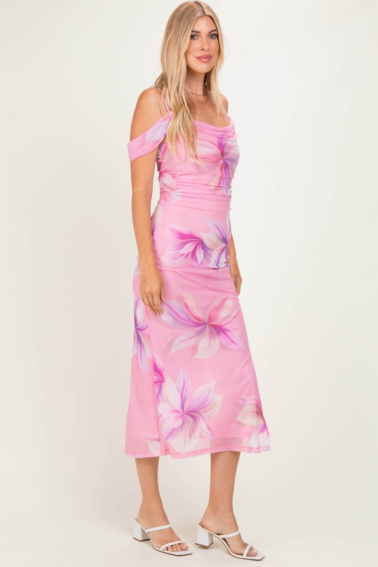 woman wearing a pink floral off-shoulder midi dress with a fitted bodice and flowy skirt