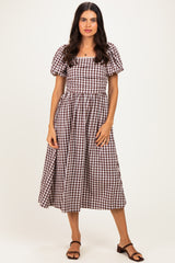 woman wearing a brown and white checkered midi dress with puff sleeves and a square neckline