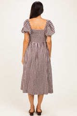 woman wearing a brown and white checkered midi dress with puff sleeves, showing the back view