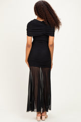 woman wearing a black ruched gown with a sheer skirt, showing the back view and curly hair styled down