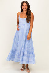 woman wearing a light blue striped maternity maxi dress with a tiered hemline and holding her baby bump