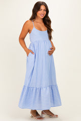 woman wearing a light blue striped maternity maxi dress with pockets and a baby bump visible