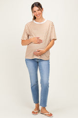 woman wearing a striped tan and white maternity t-shirt and holding her baby bump with light blue jeans