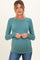 woman wearing a teal ribbed long sleeve maternity top and showing her baby bump