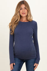 woman wearing a navy blue ribbed maternity top with long sleeves and a visible baby bump