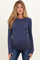 woman wearing a navy blue ribbed maternity top with long sleeves and a visible baby bump