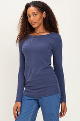 woman wearing a navy blue ribbed long sleeve top with a crew neckline and styled with denim jeans