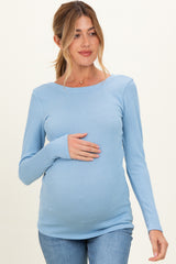 woman wearing a light blue ribbed long sleeve maternity top and holding her baby bump