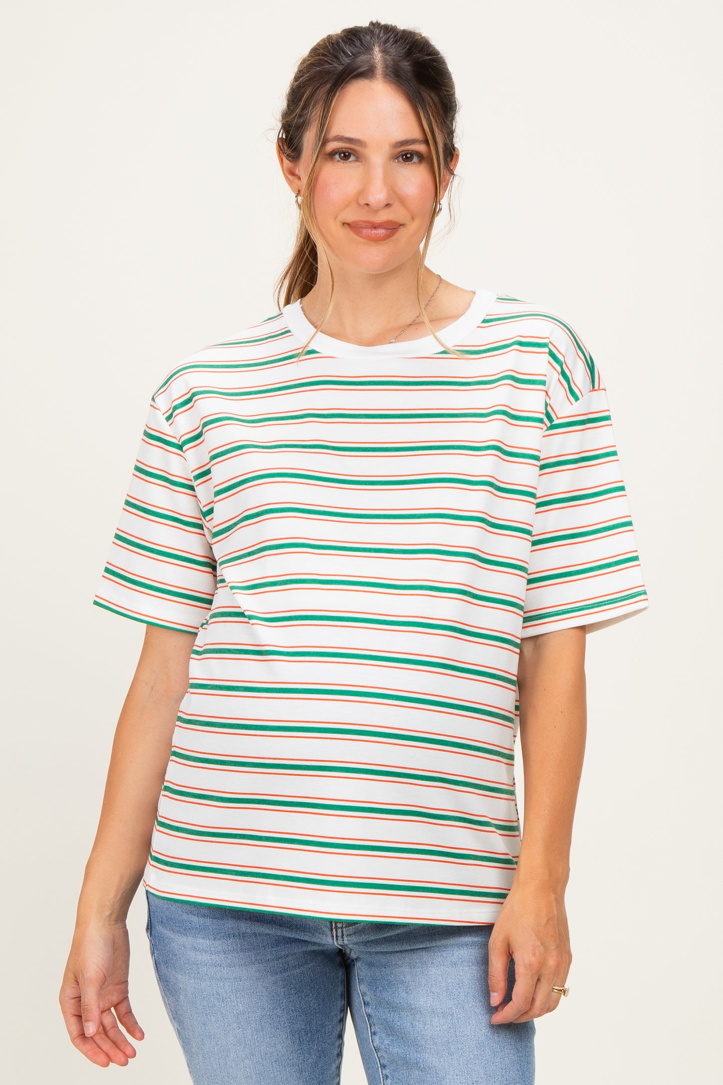 woman wearing a striped maternity top with green, red, and white stripes and a relaxed fit