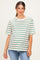 woman wearing a striped maternity top with green, red, and white stripes and a relaxed fit