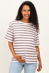 woman wearing a striped maternity t-shirt in white, red, and blue, holding her baby bump with a smile