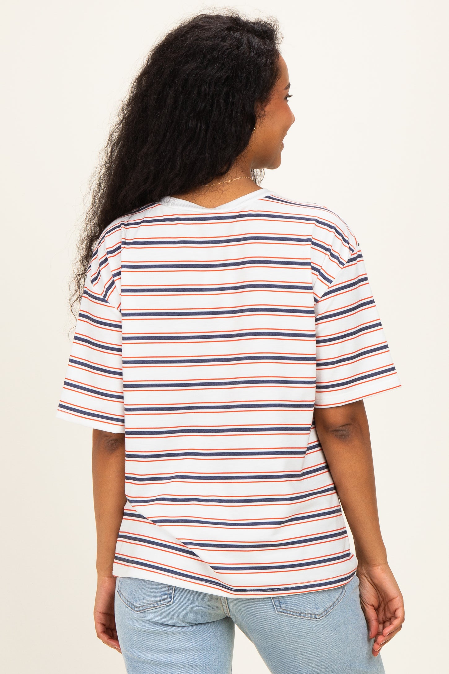 woman wearing a white striped maternity t-shirt with short sleeves and a relaxed fit, showing the back view