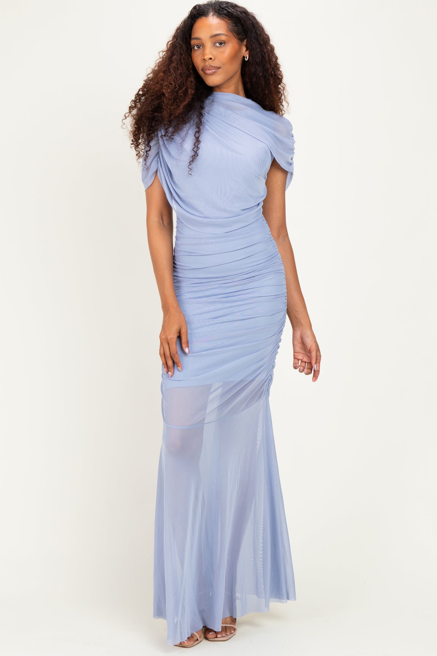 woman wearing a light blue ruched evening gown with a fitted silhouette and off-the-shoulder detail