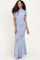 woman wearing a light blue ruched evening gown with a fitted silhouette and off-the-shoulder detail