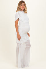 woman wearing a white ruched maternity dress with a flowy silhouette and short sleeves, showcasing her baby bump