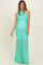 woman wearing a mint green one-shoulder maternity gown with gathered detailing and a flowy skirt, showcasing her baby bump